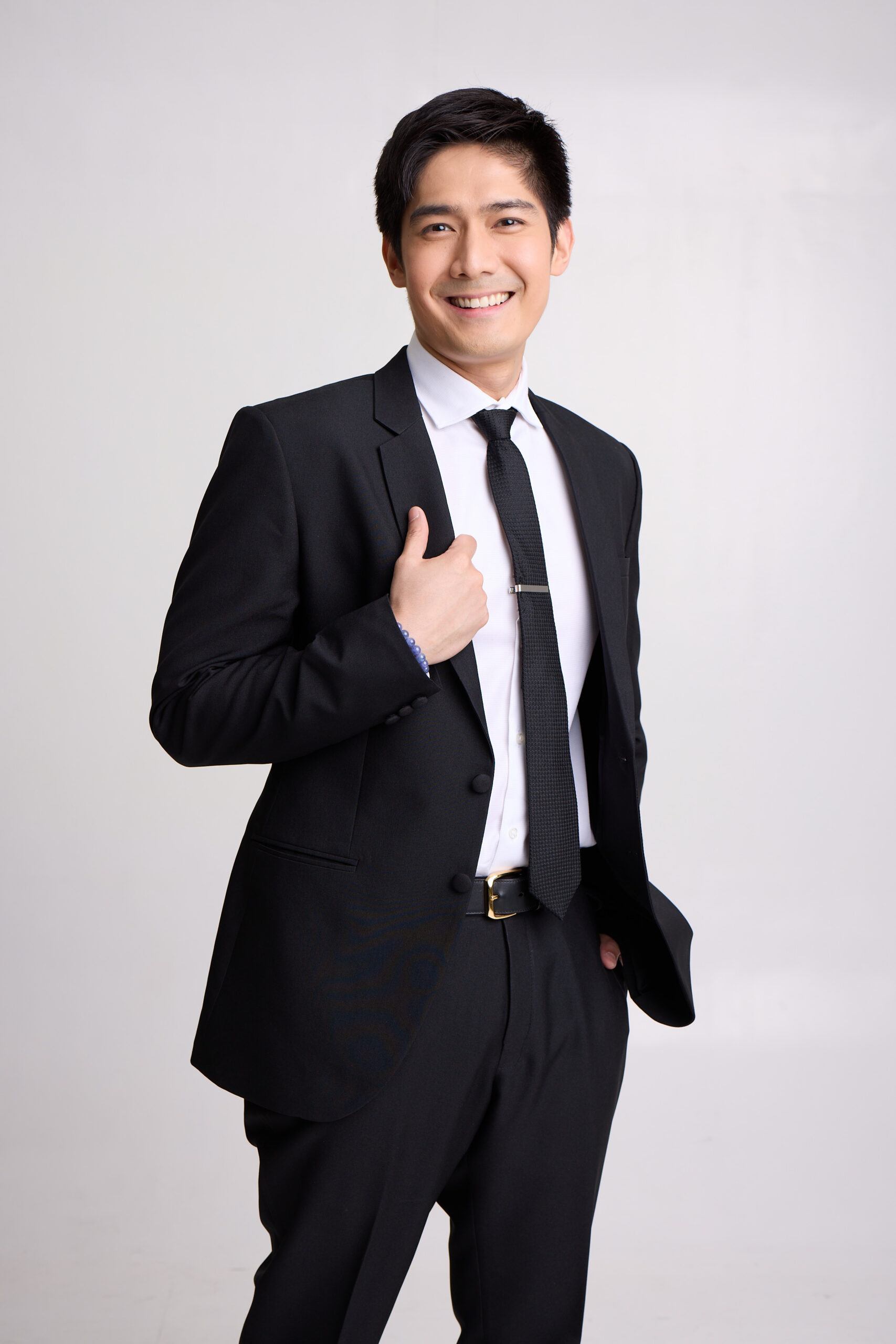 Portrait of Robi Domingo in a black suit and tie